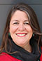 Traci Sorell headshot. Tracy, a light-skinned indigenous woman with long brown hair, wears a black scarf and red shirt.